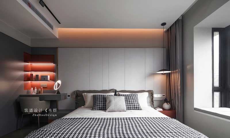 卧室空间选用大量的灰色调，营造空间安静的氛围，在宁静平和的睡眠氛围中，柔软的织品更添舒适感，橙色的灯光打破了深色软式的沉闷，令空间更为平衡。
