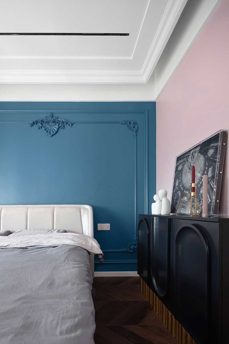 藏蓝色的床头背景墙渲染出法式的精致，对称的雕花细节点缀空间浪漫优雅的情调，搭配艺术感十足的软装摆件，主卧的法式美学意境不言而喻。