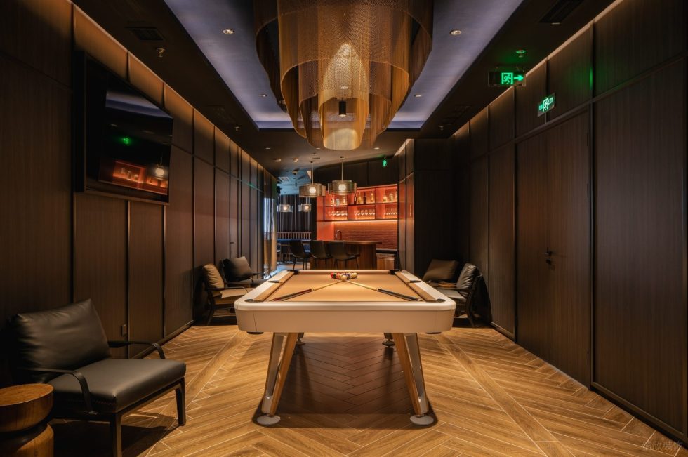 现代轻奢风高级餐厅装修设计暖黄人字木地板搭深色装饰墙桌球休闲区设计图